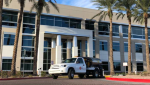 One Stop Property Services sweeping truck parked outside modern office building