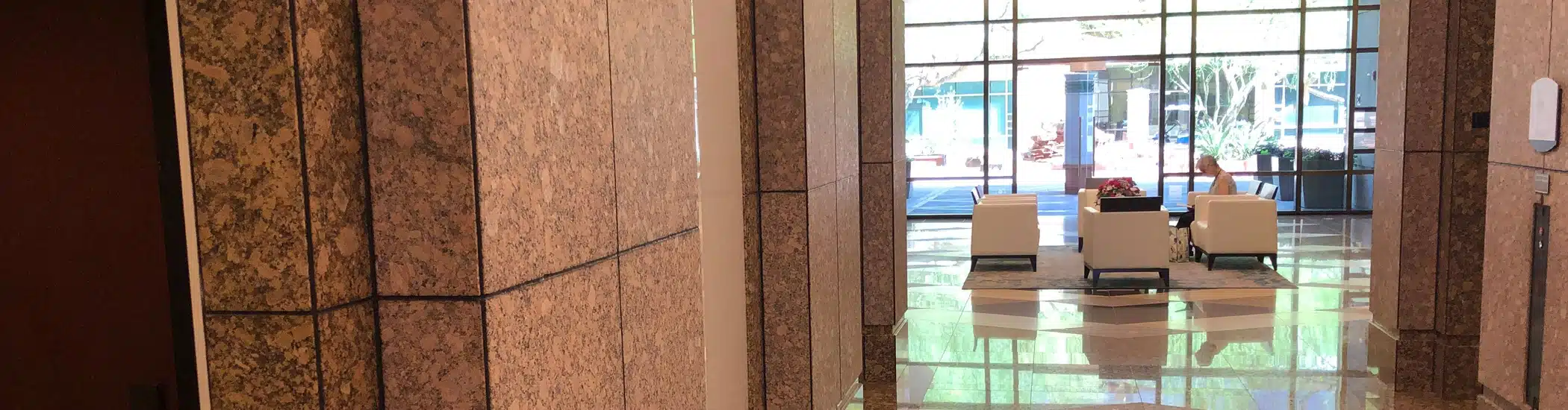 Clean and polished office building lobby with modern furniture and marble floors
