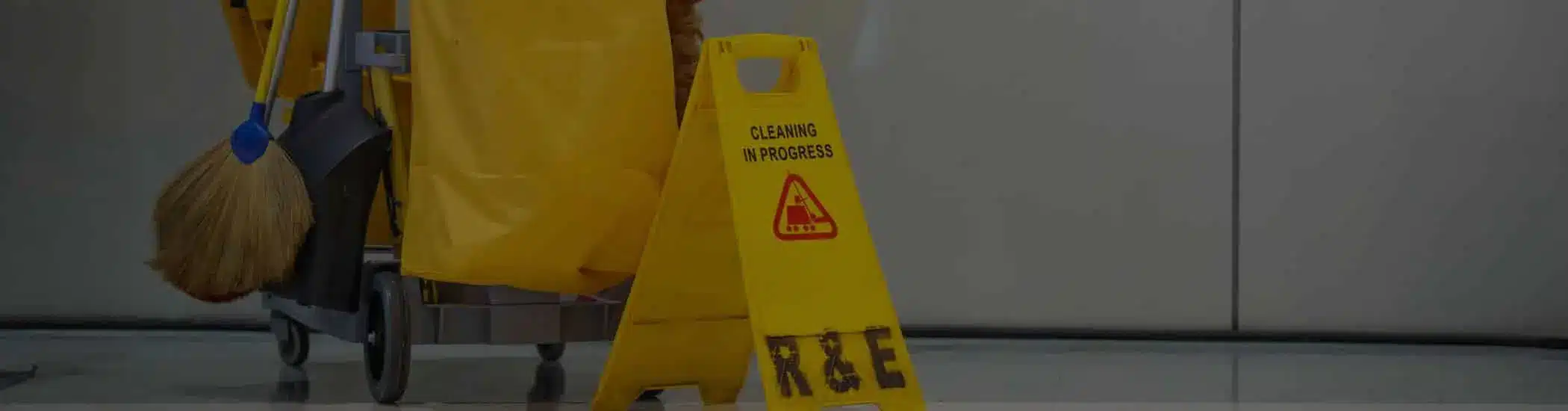 Cleaning cart and “Cleaning in Progress” safety sign in commercial hallway – One Stop Property Services