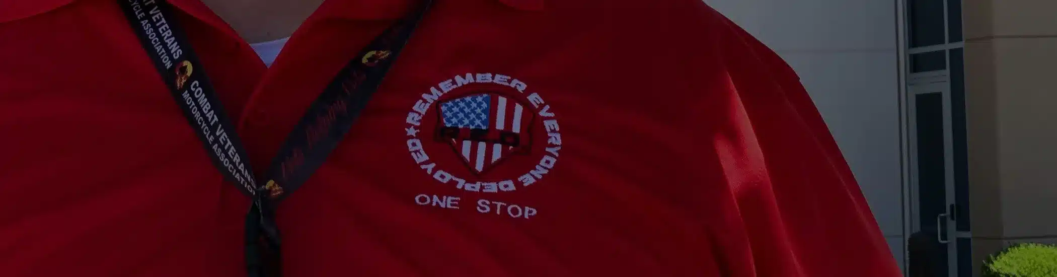 Close-up of a One Stop employee shirt with a veteran support badge reading “Remember Everyone Deployed”