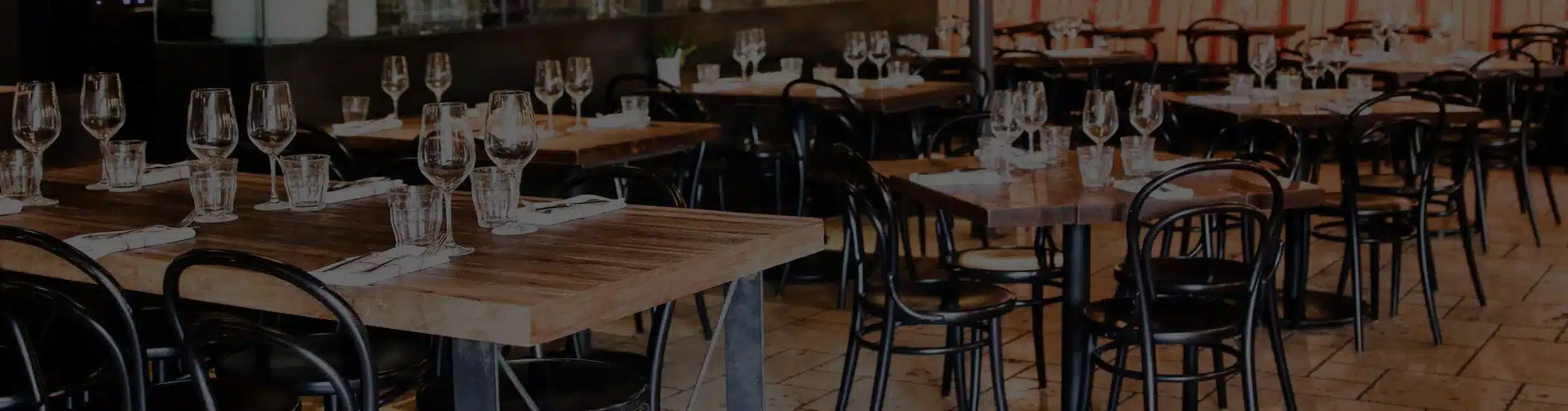 Spotless restaurant dining area with neatly arranged tables and chairs cleaned by One Stop Property Services