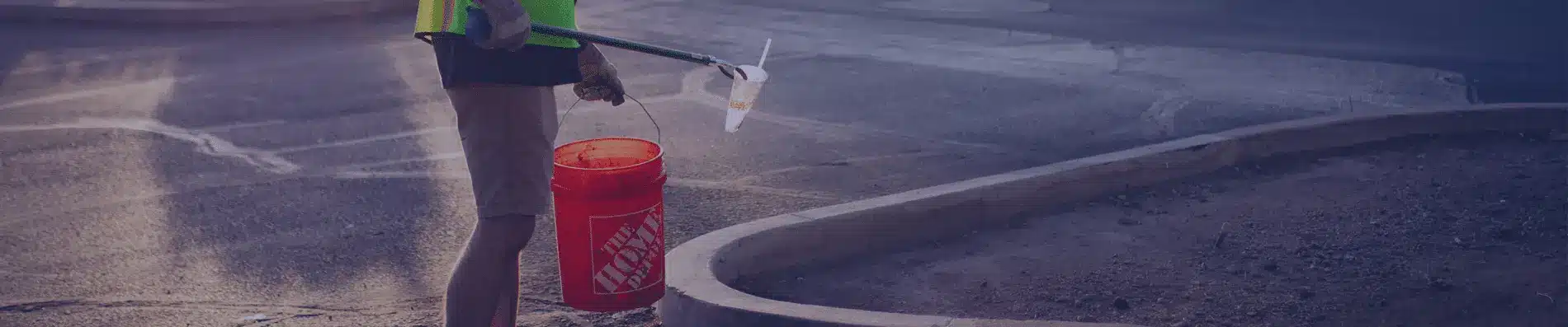 One Stop Property Services worker collecting litter with grabber tool in parking lot